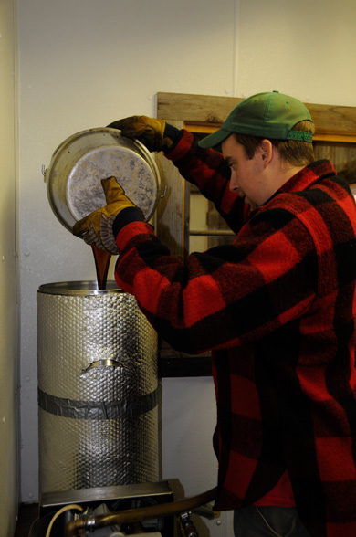 Ted Glabach  pouring just drawn off sap into one of many filtration systems used in the making of syrup - a compression system that will filter out the last large bits of minerals resulting in a sugar sand.